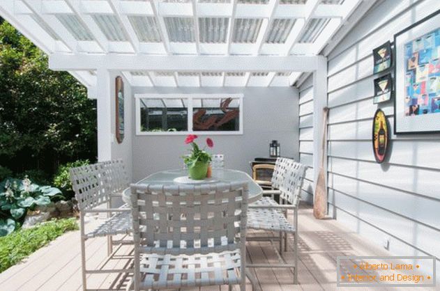 An open polycarbonate porch attached to the house