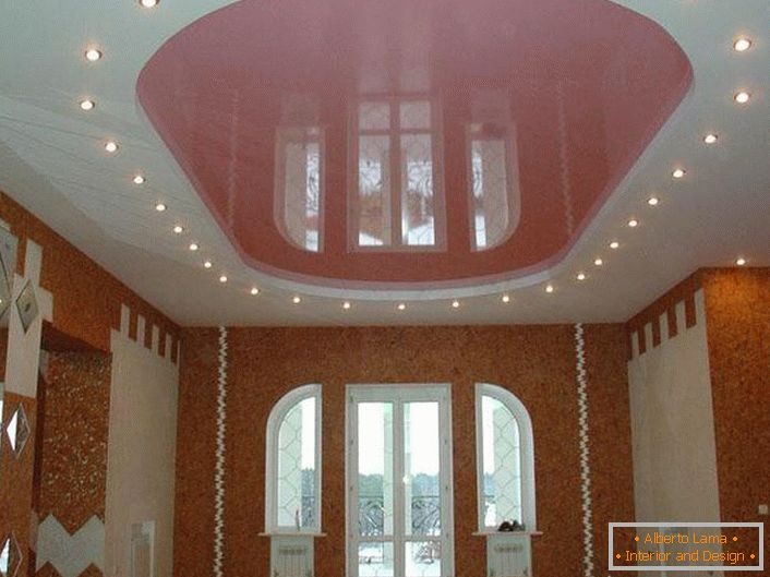 Pink oval stretch ceiling with LED lighting in a large room in a country house.