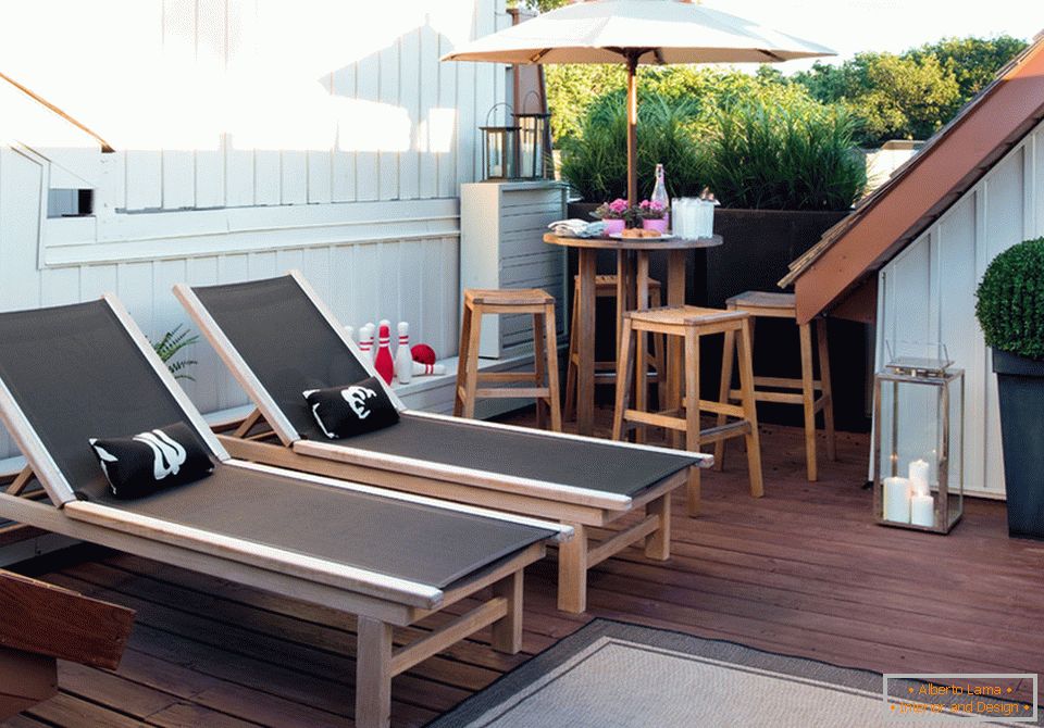 Chaise lounges and table with an umbrella on the terrace