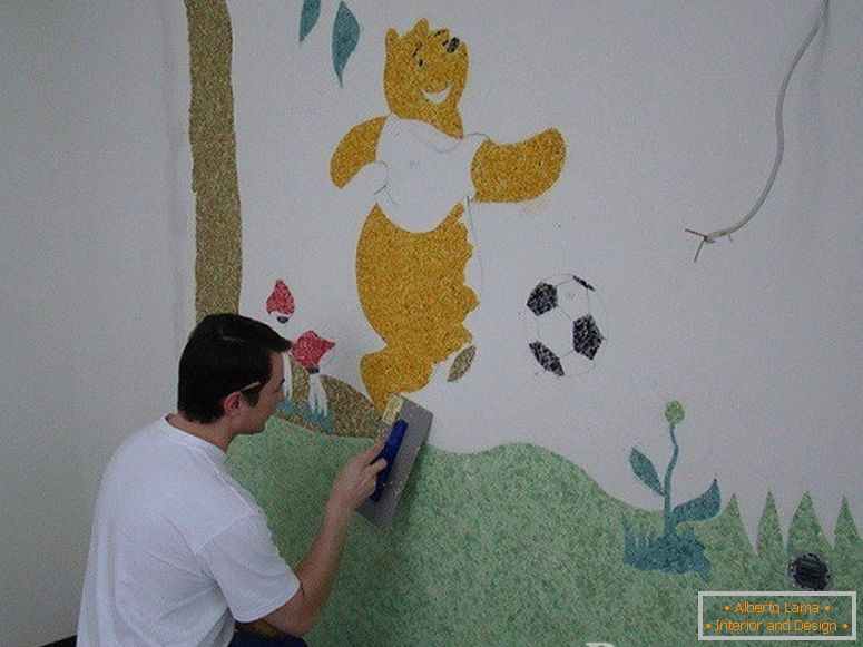 The man draws Winnie the Pooh on the wall in the nursery